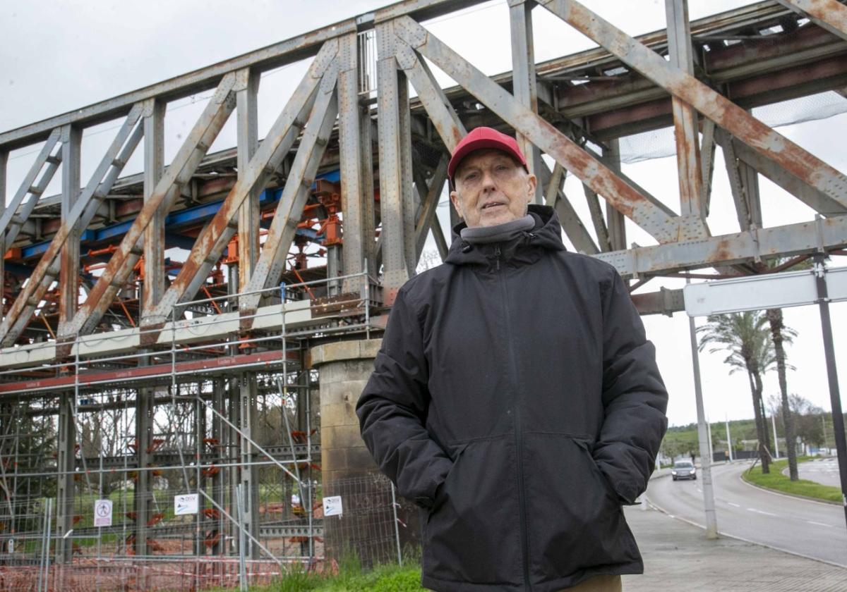 Ángel Caballero delante del Puente de Hierro, con los soportes sobre el suelo y el gato bajo las vías.