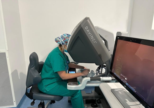 Una cirujana controla los brazos del robot con la consola.