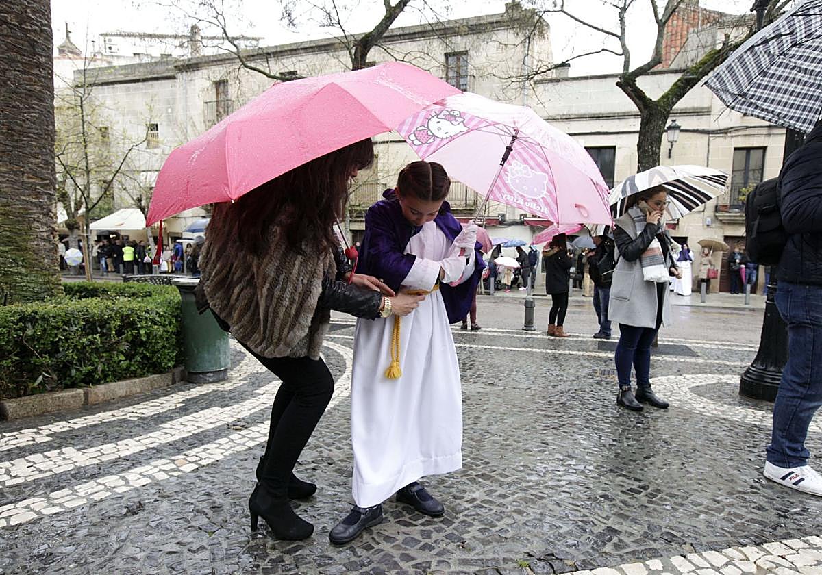 Nazarenos bajo los paraguas en el Domingo de Ramos de Cáceres en el año 2016.