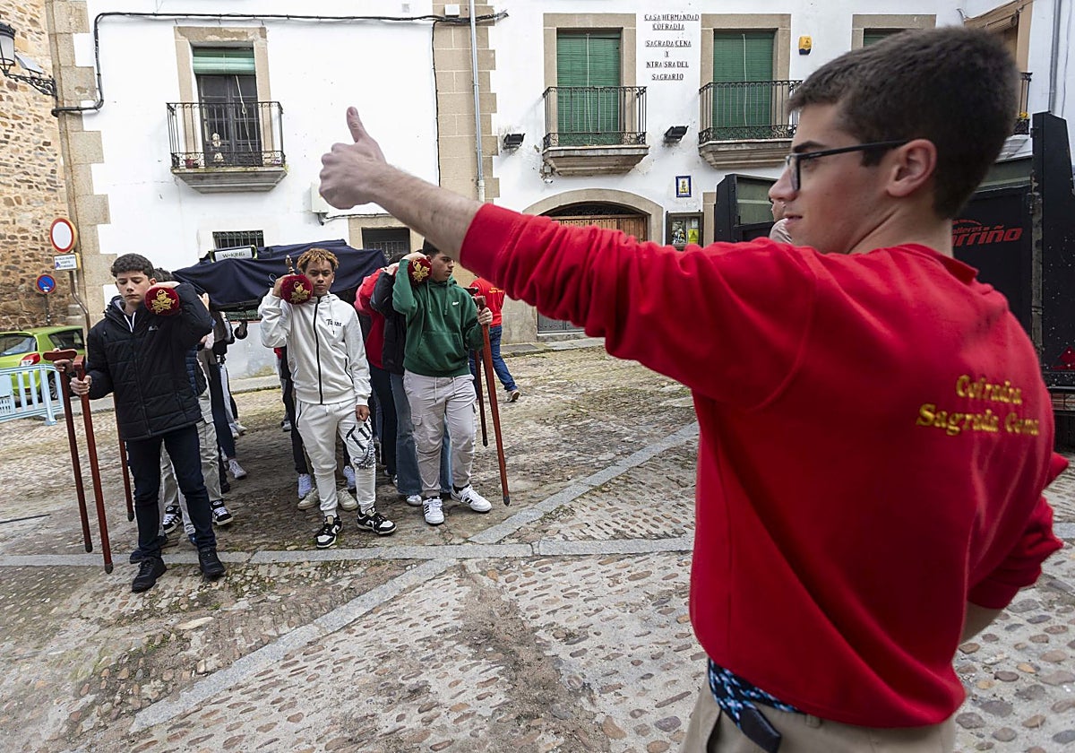 Ensayo de los hermanos de carga del paso juvenil del Triunfo de la Eucaristía de la Sagrada Cena, el sábado pasado en la plaza de Santiago de Cáceres.