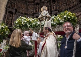 El obispo, Jesús Pulido, imparte la bendición a uno de los 86 niños que este miércoles han sido presentados ante la patrona de Cáceres, que ha lucido el manto número 8.