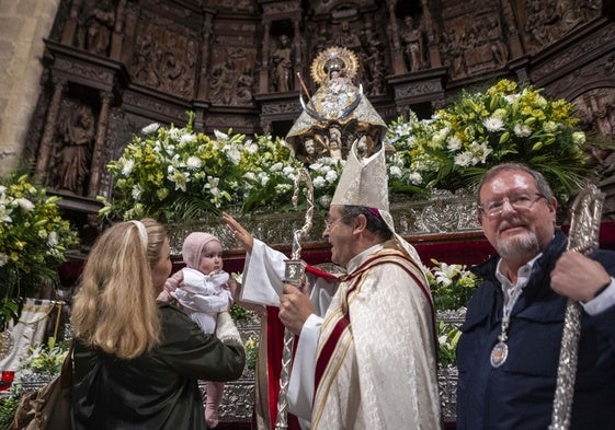 El obispo, Jesús Pulido, imparte la bendición a uno de los 86 niños que este miércoles han sido presentados ante la patrona de Cáceres, que ha lucido el manto número 8.