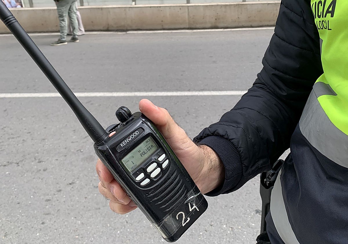 Un agente muestra uno de los 'talkies' antiguos, con cinta adhesiva para que no se salga la batería.