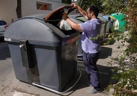 Un pacense deposita restos orgánicos en el contenedor marrón.