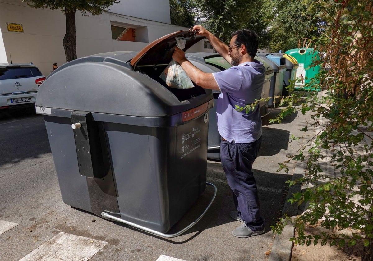Un pacense deposita restos orgánicos en el contenedor marrón.