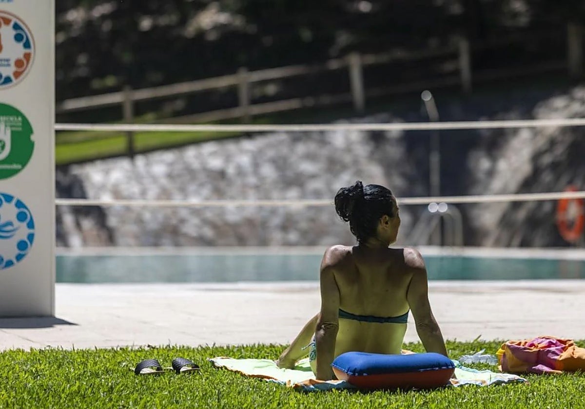 Una bañista toma el sol durante la temporada de verano en las piscinas municipales.