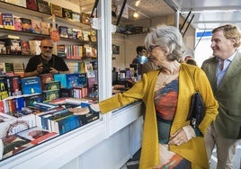 Pilar del Río e Ignacio Gragera miran libros en una caseta de la Feria del Libro de Badajoz, este viernes.