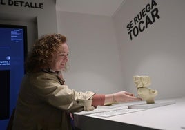 Una visitante del museo toca una representación de un rostro del Turuñuelo.