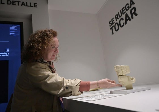 Una visitante del museo toca una representación de un rostro del Turuñuelo.