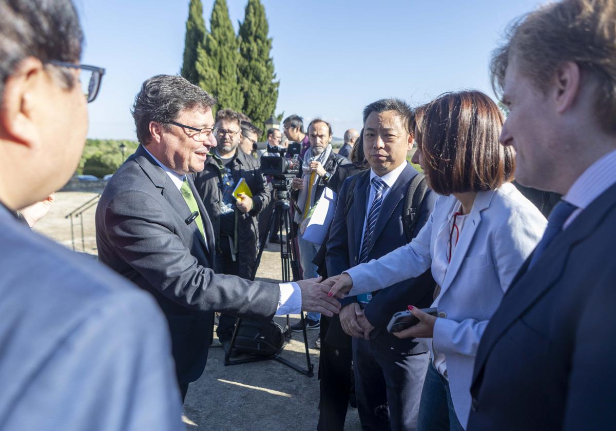 El consejero de Economía saluda a participantes en el el II Foro Internacional sobre Movilidad Eléctrica e Hidrógeno, en Cáceres.