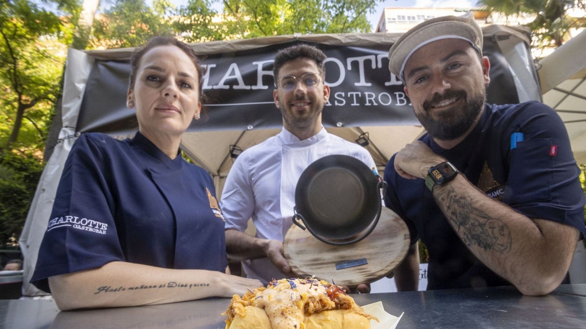 Janira Sánchez (cocinera), Rubén Márquez (propietario) y Manuel Jordán (cocinero), del gastrobar Charlotte, posan junto a la tapa ganadora de Extregusta: brioche de cordero con confituras de cerezas del Jerte.