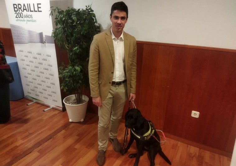 Román junto a Troya, su perra guía.
