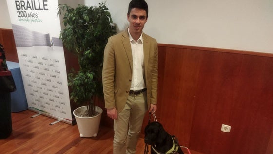 Román junto a Troya, su perra guía.