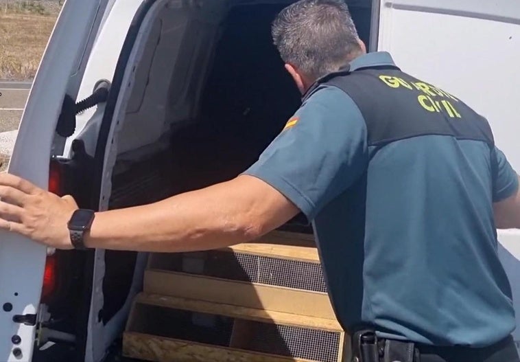 Un agente de la Guardia Civil de Cáceres inspecciones un vehículo con especies animales, durante la operación.