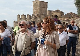 La guía Alicia Ruiz, en primer plano con micrófono, durante una visita guiada en Trujillo.