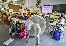 Alumnos combaten con sprays las altas temperaturas en un colegio en una imagen de archivo.