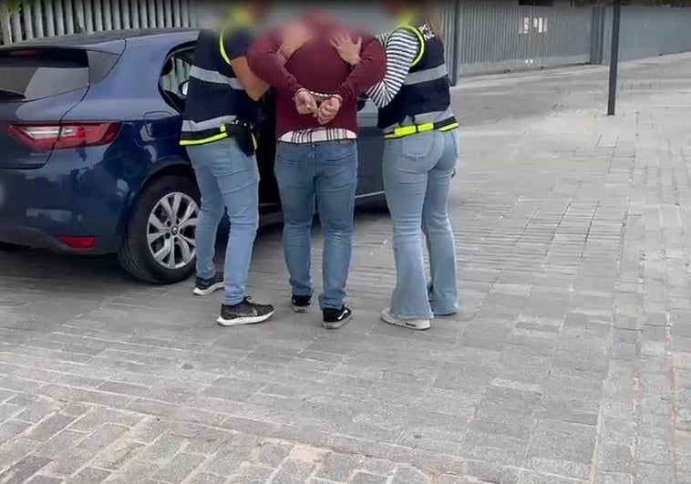 Agentes de la Policía Nacional introducen en el vehículo a uno de los detenidos.