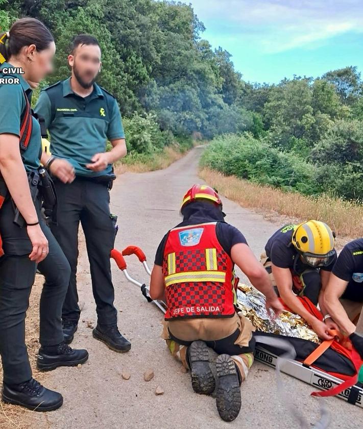 Imagen secundaria 2 - El equipo de rescate tuvo que sortear grandes piedras para llevar a la mujer hasta la ambulancia que la esperaba en una pista.