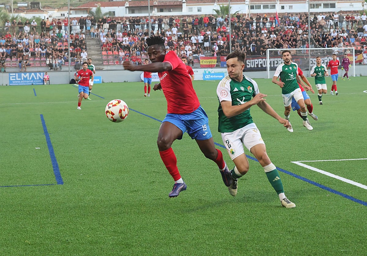 Iván Martínez defiende a Dago en el Estepona-Cacereño del playoff de ascenso.