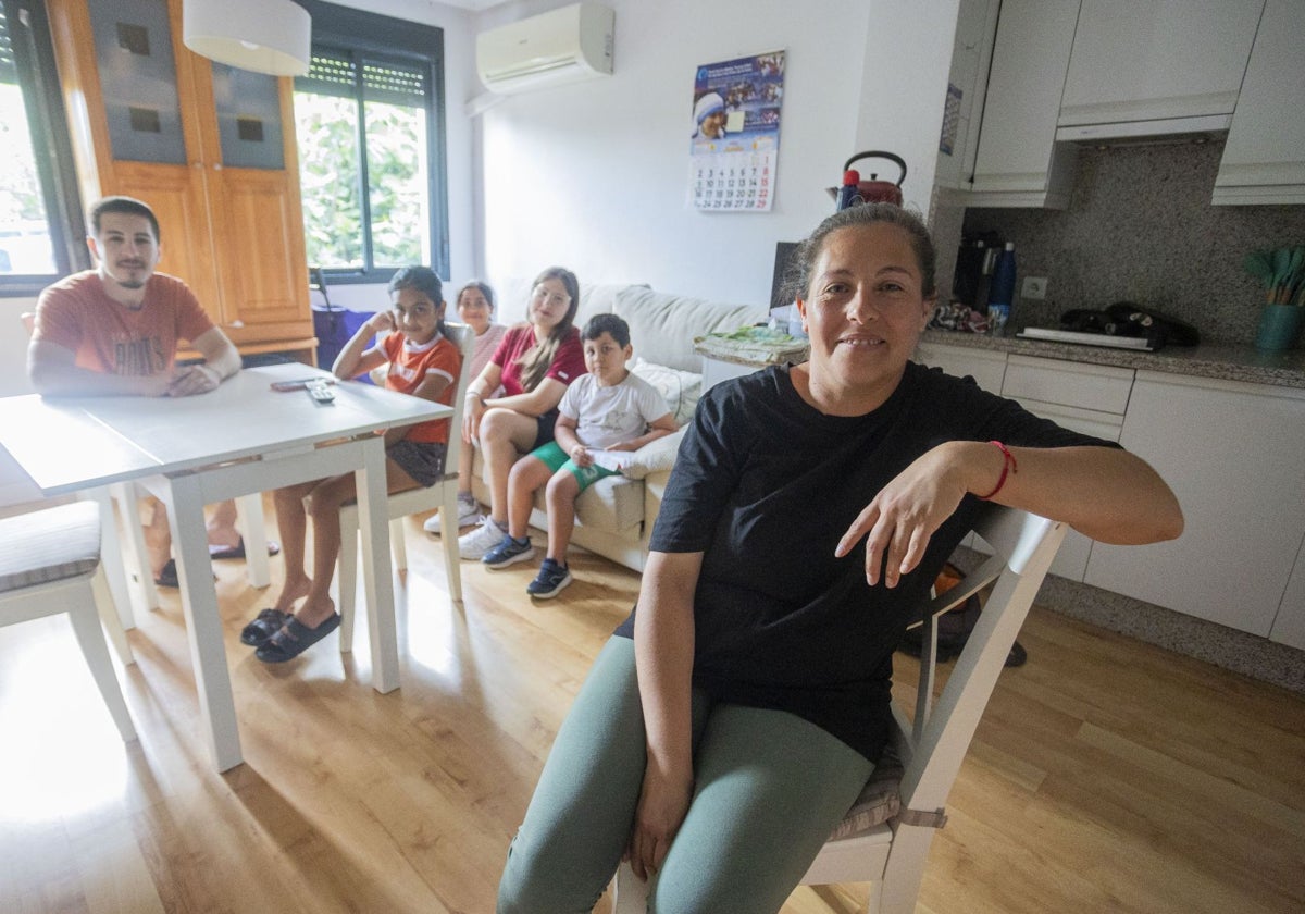 Fátima, en primer plano, junto a sus cuatro hijos y su hermano, Carlos Alberto, en la vivienda que comparte en la calle Miralrío de Cáceres. En la foto falta el marido de Fátima, que también reside en este piso.