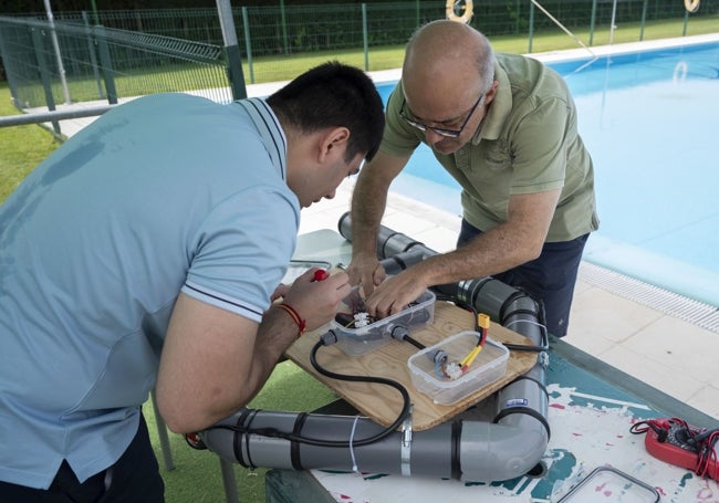 Alumno y profesor haciendo algunos ajustes antes de lanzar el prototipo al agua.