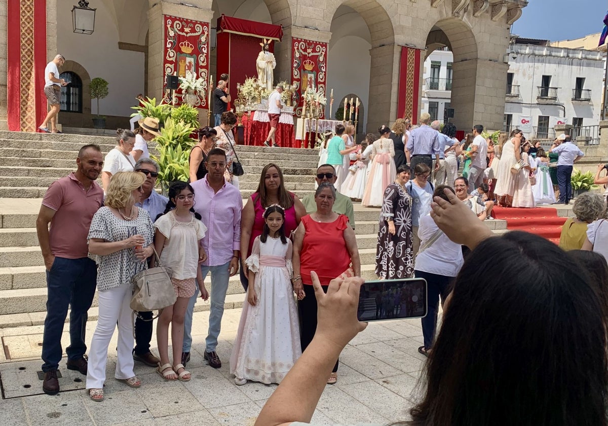 Una familia de Primera Comunión se fotografía ante el altar de las escalinatas municipales.
