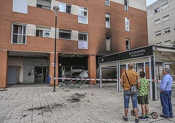Varios vecinos observan los daños que ha sufrido el bar Alejandría.