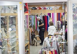 El equipo de guías caninos de la Policía Nacional registra la tienda.