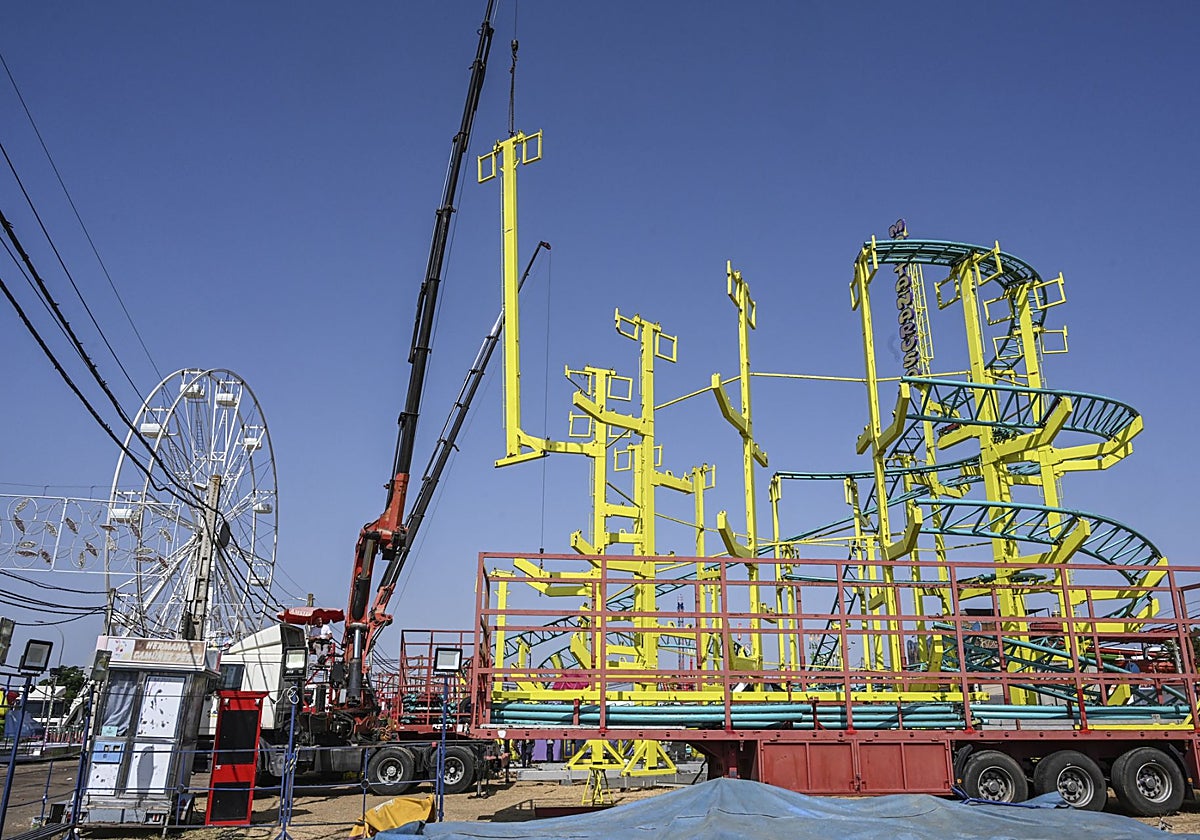La montaña rusa, en desmontaje con la noria también a medias al fondo, en esta mañana de domingo.