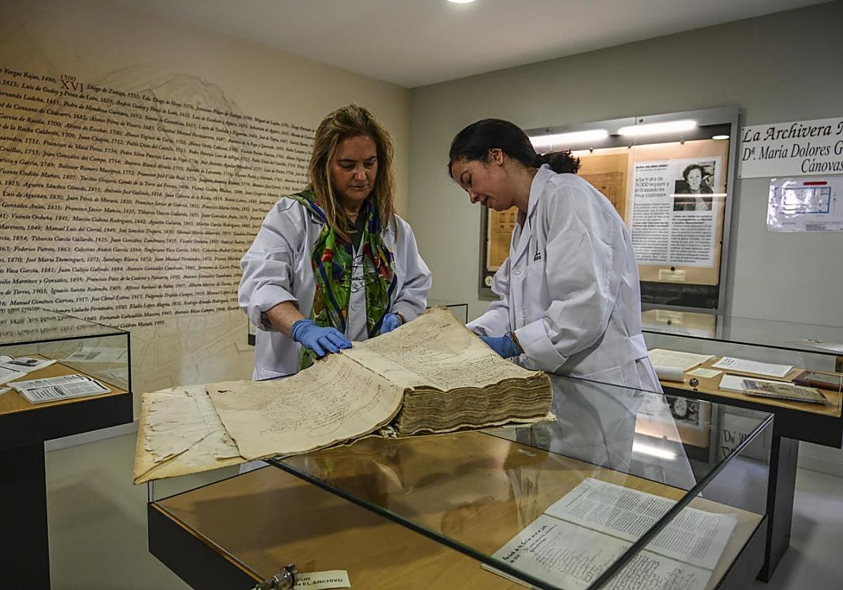 Fátima Cancho y Emiliana con el libro más antiguo del archivo municipal que transcribió Gómez-Tejedor.