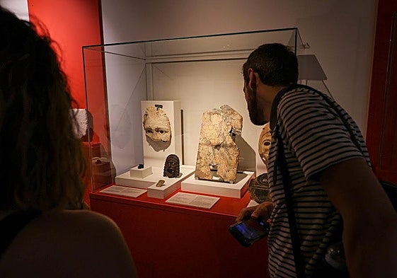 Visitantes observan varias piezas en la inauguración de la muestra.