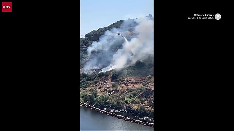 Los bomberos intentan apagar un incendio forestal entre los dos puentes de Alcántara