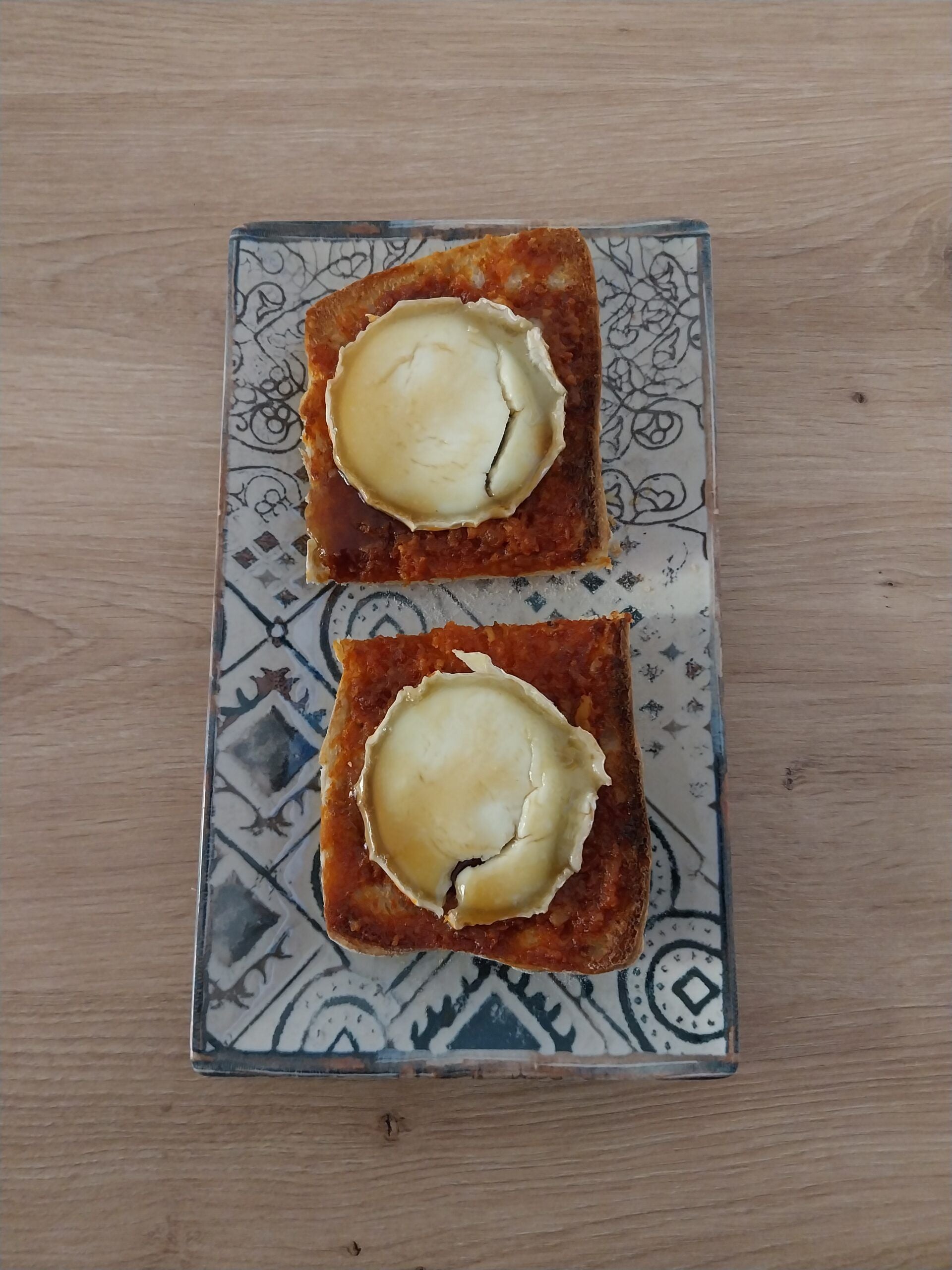 Tuestan el pan de chapada. A continuación untan la patatera y sobre ella colocan dos lonchas de rulo de queso y ponen a gratinar. Para finalizar ponen sobre el rulo la miel.