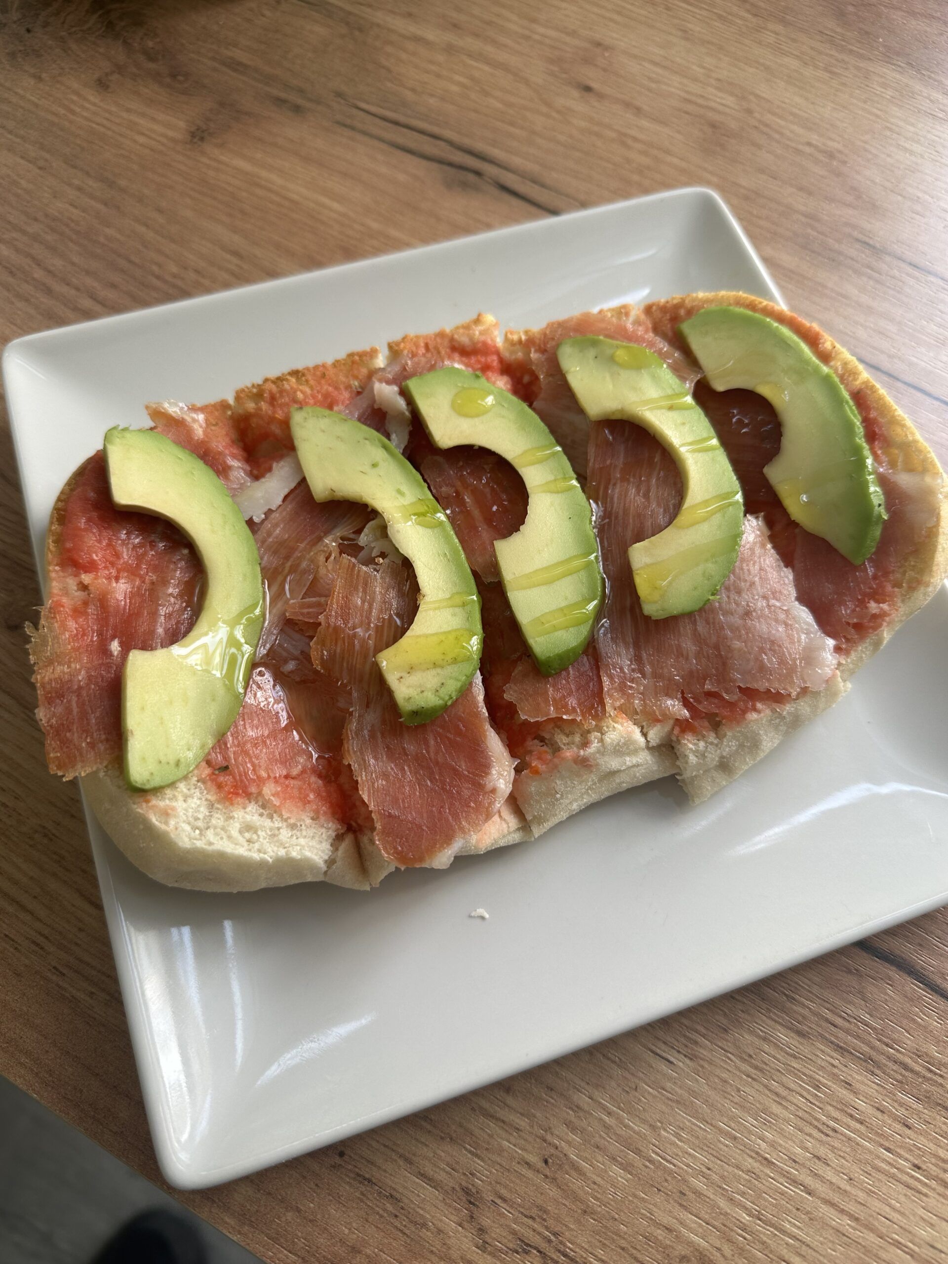 Tostada deliciosa con un base de tomate con orégano, jamón serrano y con deliciosas laminas de aguacate