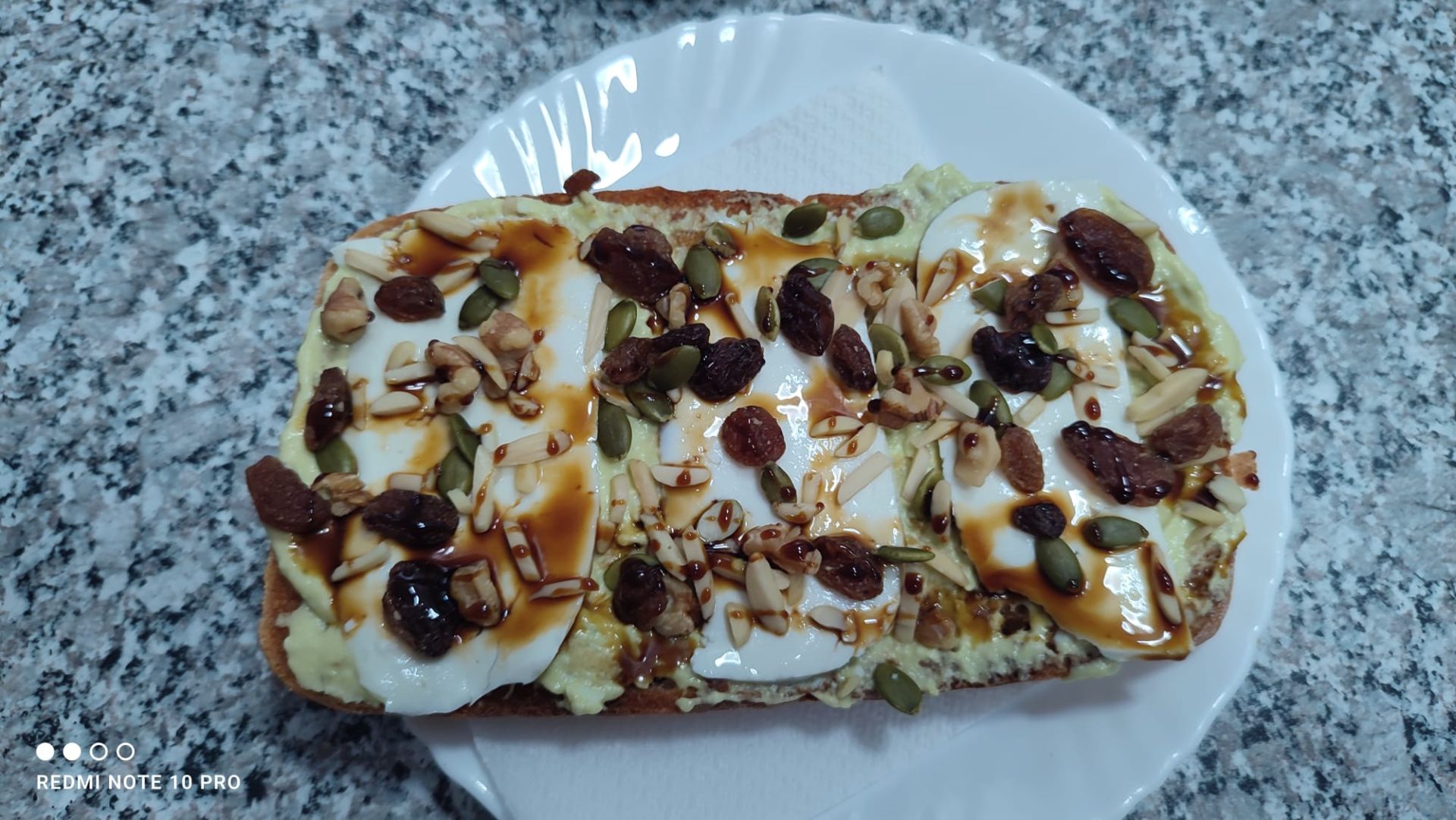 Una combinación irresistible: pan de vienesa artesanal, con una cremosa mayonesa de aguacate, queso fresco de vaca y cabra, un toque crujiente de frutos secos y el dulzor perfecto de la miel de caña.