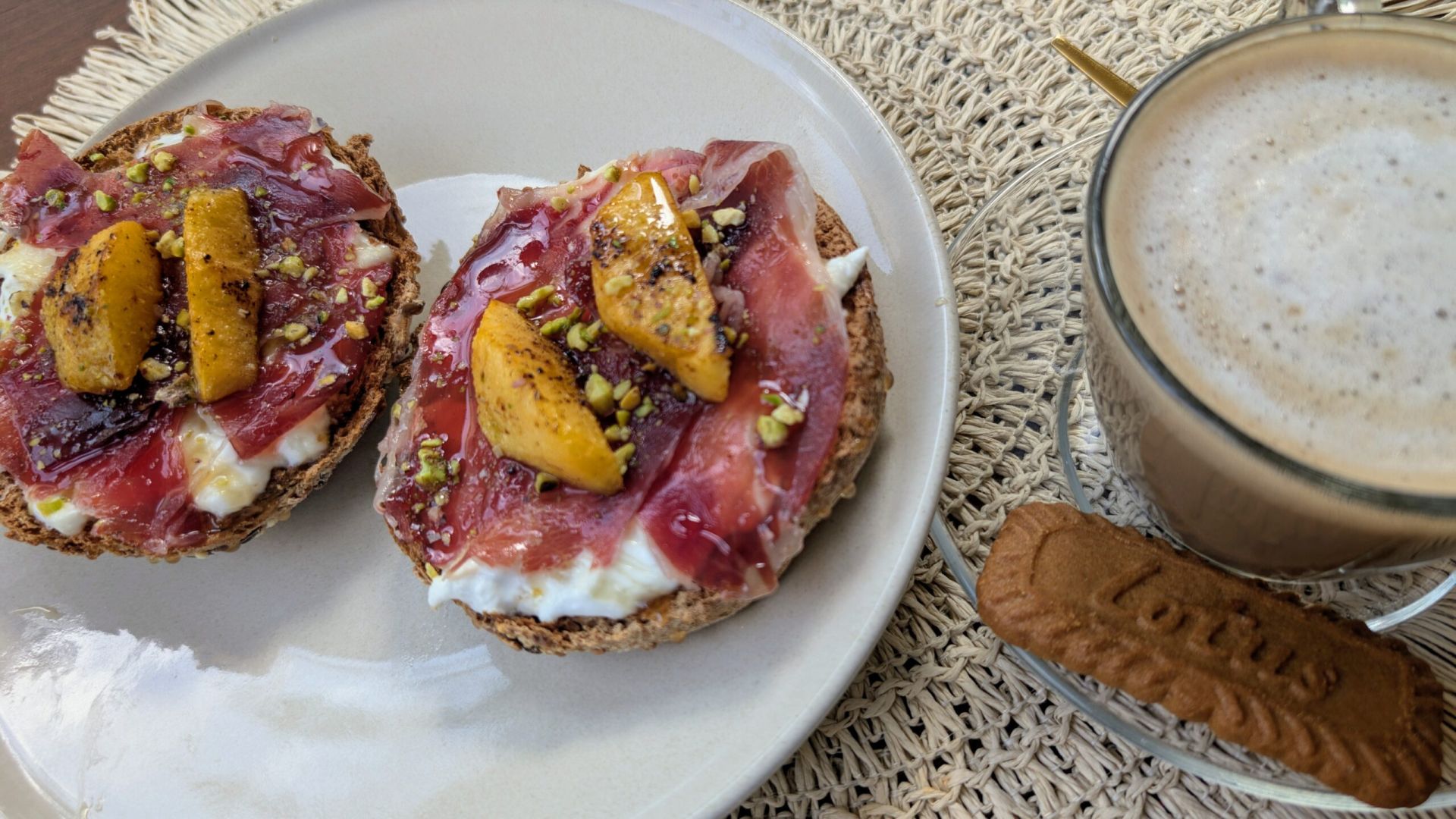 Pensar en los ingredientes de esta tostada es pensar en el verano. A elegir entre mollete de pan de pueblo, de los de antes, o bollito integral 100% de masa madre y semillas. Con una base de Burrata y AOVE, paleta ibérica, melocotón caramelizado a fuego lento en su propio jugo, sin azúcar, pistacho troceado y un toque de miel. El balance perfecto de ingredientes que te sorprenderá desde el primer bocado.