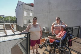 Antonio Rodríguez con su mujer y su hija junto a la escalera que le impide bajar a la calle.
