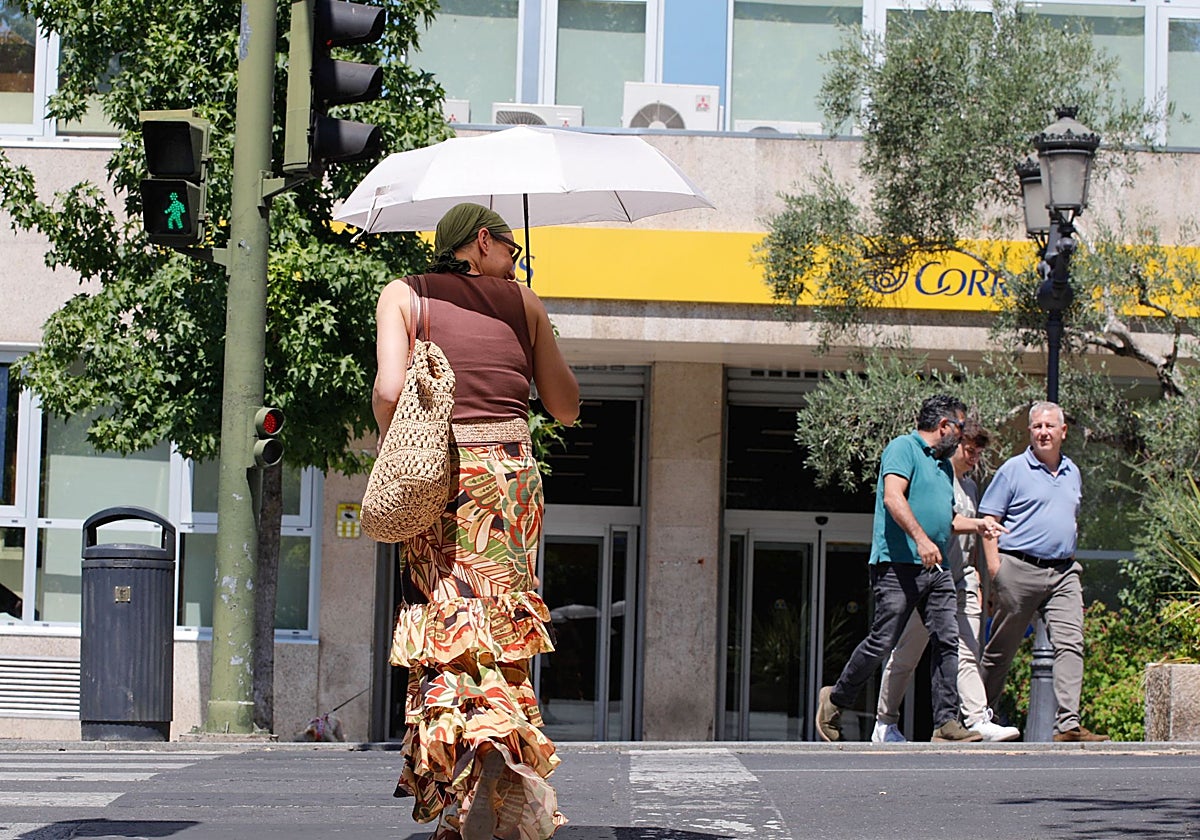 Imagen de archivo de una mujer protegiéndose del calor en Cáceres.