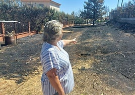 Sofía Halcón, vecina de Las Vaguadas, señala la zona que ha ardido junto a su casa.
