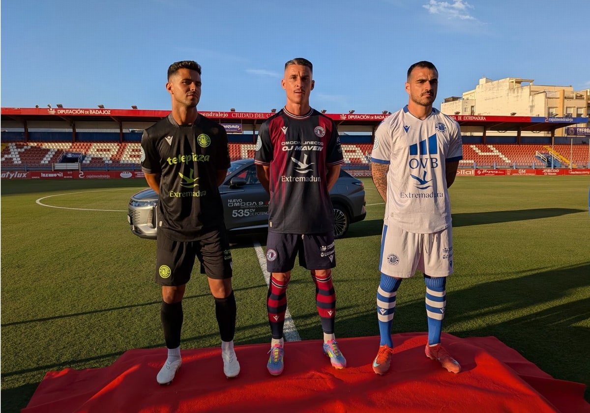 Los jugadores del Extremadura Fran Rosales, Callejón y Dieguito posan con las tres nuevas equipaciones en el Francisco de la Hera.