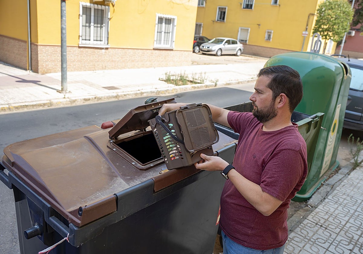 Un vecino utilizando el contenedor marrón para reciclar residuos orgánicos en Badajoz.
