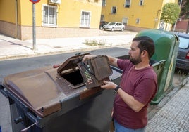 Un vecino utilizando el contenedor marrón para reciclar residuos orgánicos en Badajoz.