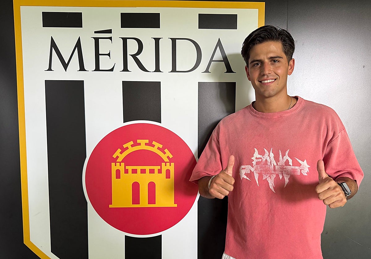 Miguel Jiménez «Capi» junto al escudo del Mérida.