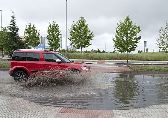 Un coche pasando por una balsa de agua en Badajoz.