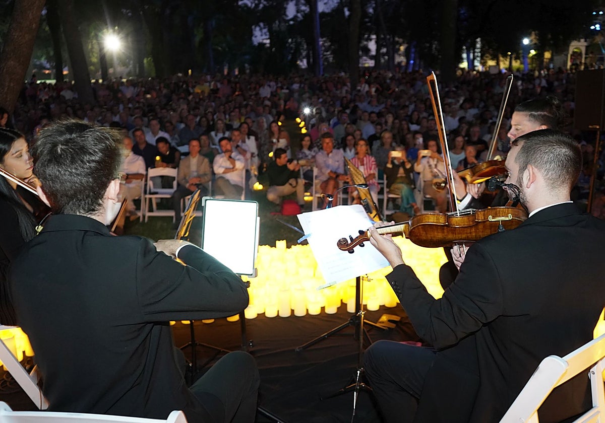Concierto de inauguración de la Noche en Blanco 2024 en la Alcazaba rodeado de velas.