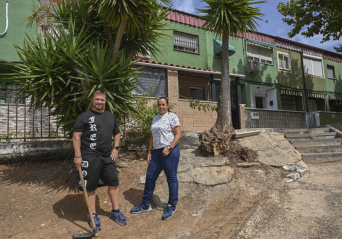 Saray Jorge y Jorge Regalado delante de su vivienda, en el talud de tierra que han limpiado.