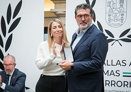 La presidenta de la Junta de Extremadura, María Guardiola, entrega una medalla al director de ABC, Julián Quirós.