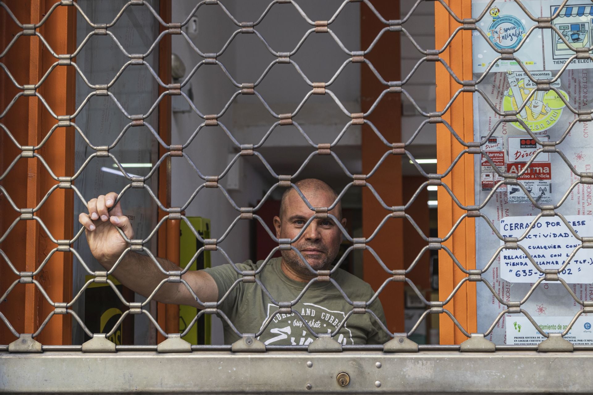 Juan Francisco bajando las persianas de su local en Badajoz.
