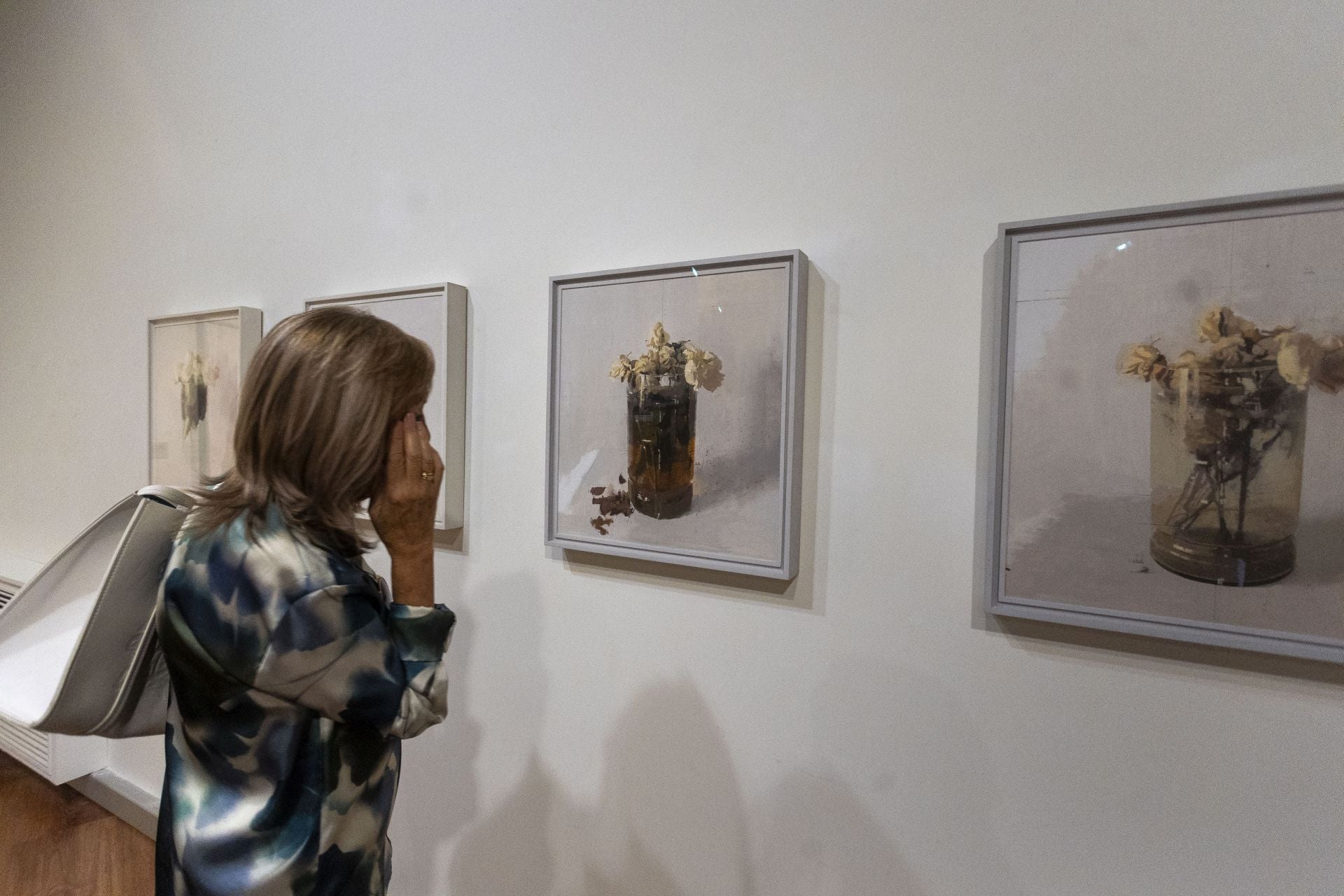 Una mujer contempla la serie 'Rosas de Ávila' del artista Antonio López.