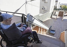 Antonio Rodríguez junto a la escalera mira la plataforma elevadora.